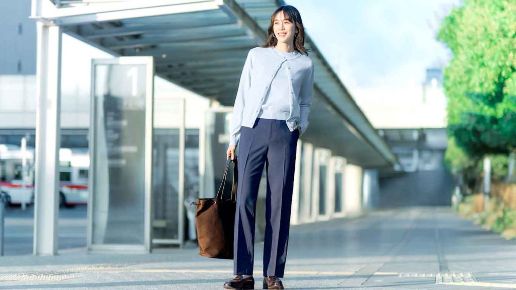 Gaya busana kerja wanita menggunakan cardigan kerah bulat proteksi sinar UV warna biru muda dari UNIQLO di halte bus